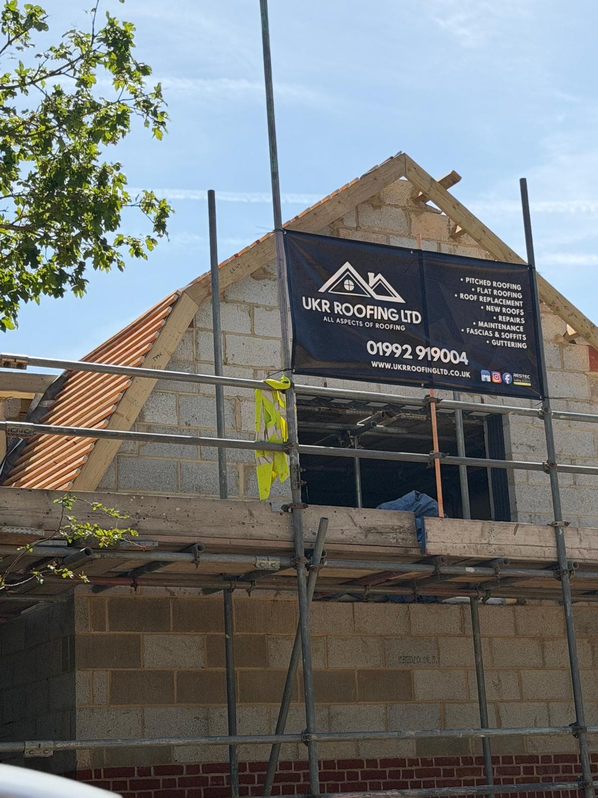 UKR Roofing banner on an active scaffolding project